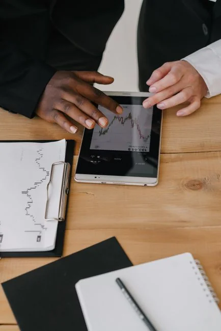 A financial vlogger in a home studio discusses cryptocurrency trends using charts and a laptop.
